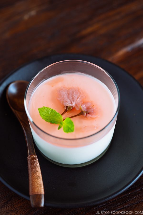 Cherry Blossom Milk Pudding in a glass cup served with green tea.