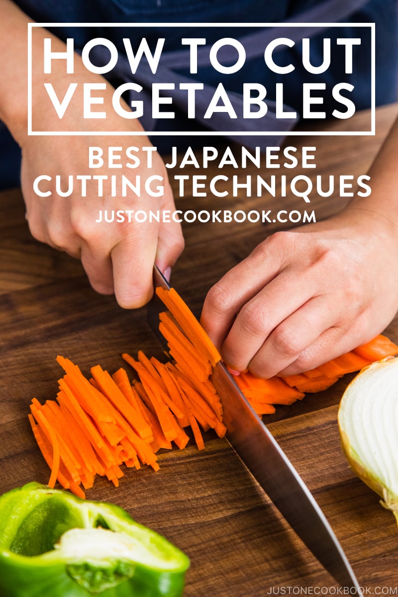 knife cutting carrots into thin strips on cutting board