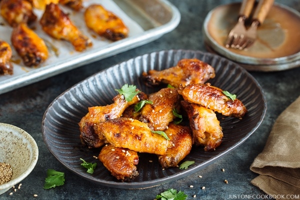 Slow Cooker Sriracha Chili Chicken Wings in a plate and a baking tray.