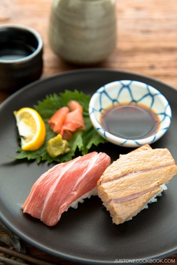 2 type of Otoro Sushi with garnish and soy sauce.