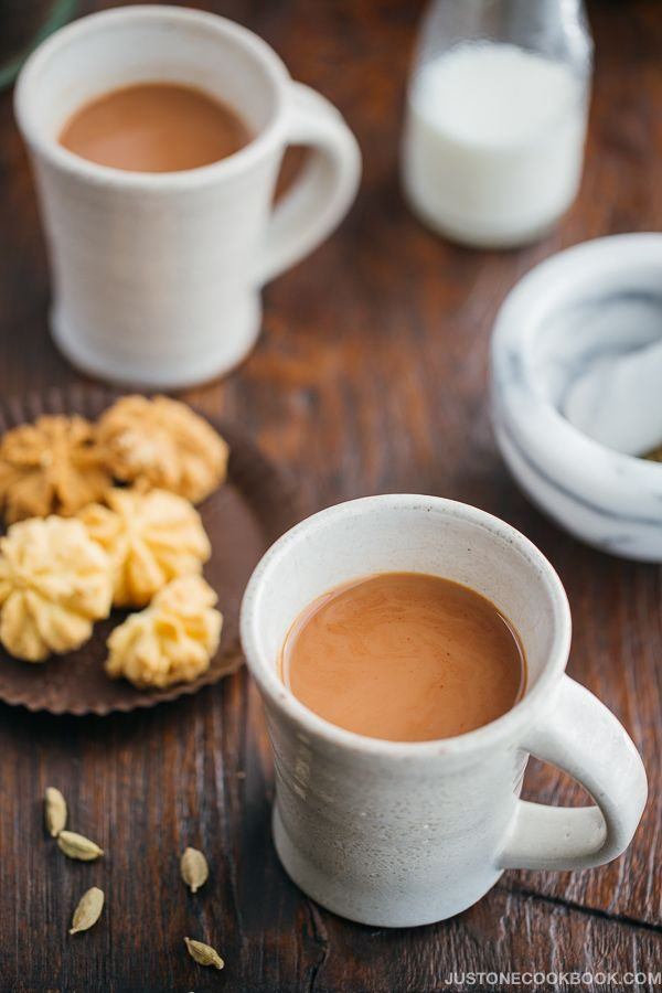 Masala Chai in cups and a plate of cookies.