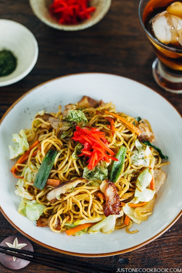 Yakisoba on a plate topped with pickled red ginger.