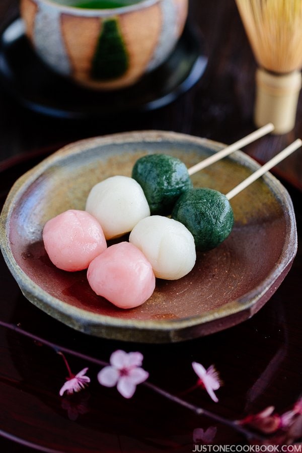 Hanami Dango on a small plate and cup of green tea.