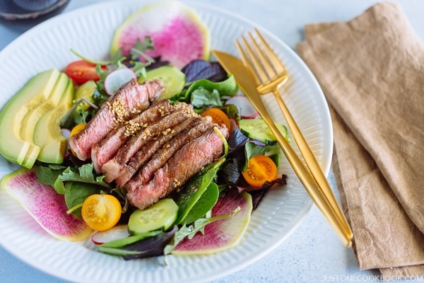 Steak Salad with Shoyu Dressing on a white plate.