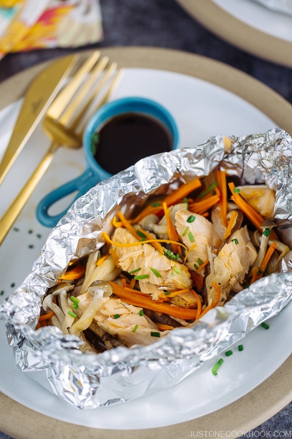 Salmon in Foil on the plate along with ponzu sauce.