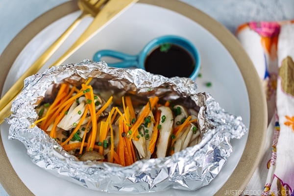 Salmon in Foil on the plate along with ponzu sauce.