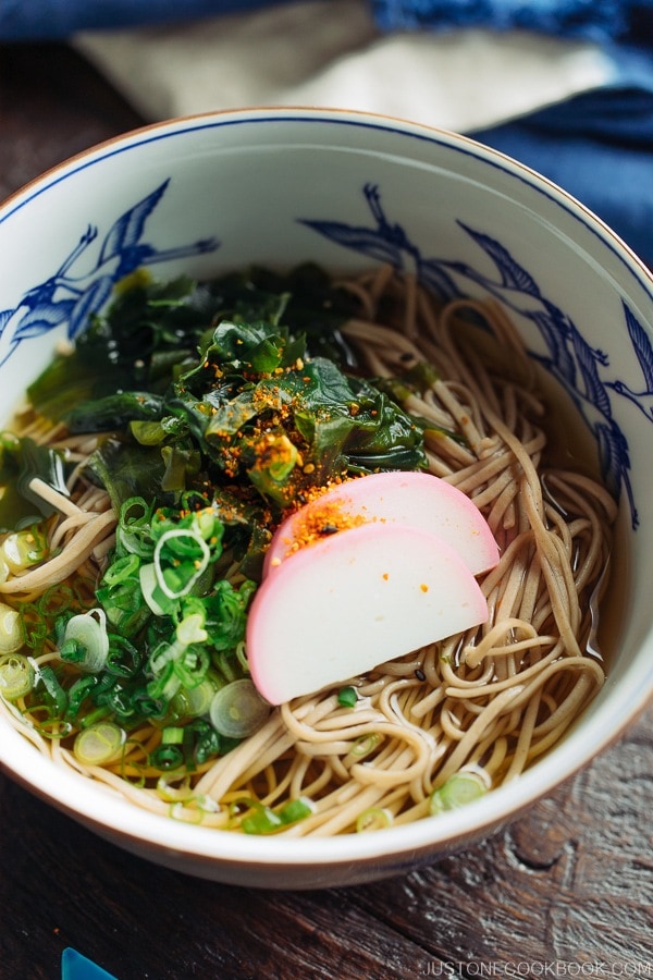 Toshikoshi Soba Noodle Soup with fish cake and wakame seaweed in a Japanese bowl.