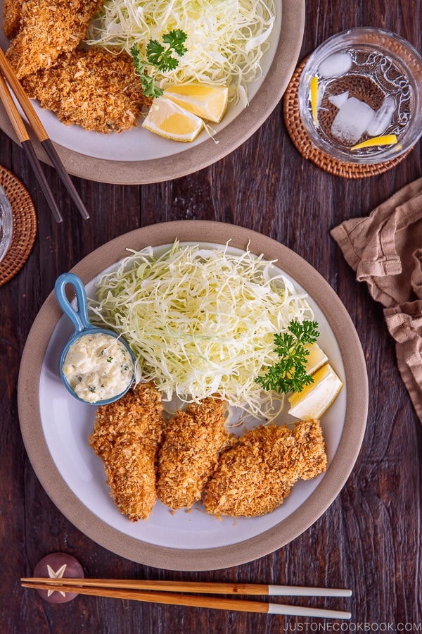 Japanese Fried Oysters (Kaki Fry) served with tartar sauce and shredded cabbage on the white plate.