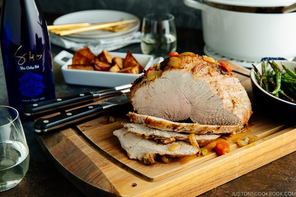 Japanese Pork Roast being sliced on a wooden cutting board.