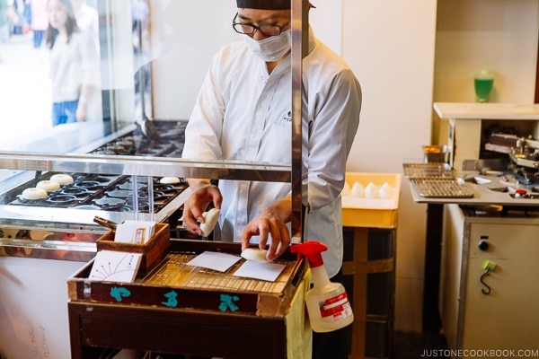 Worker placing umegaemochi on paper - Dazaifu speciality sweet - Fukuoka Travel Guide | justonecookbook.com