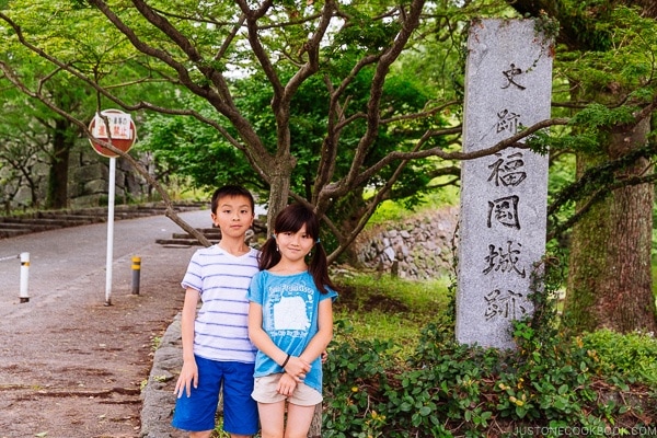 children standing next to Fukuoka Castle Ruin sign - Fukuoka Travel Guide | justonecookbook.com