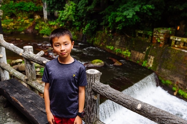 boy standing next to river bank Kurokawa Onsen Travel Guide | justonecookbook.com