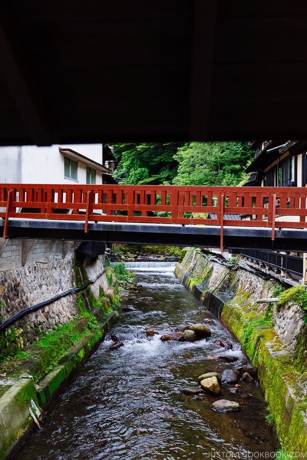 view of red pedestrian bridge at Shinmei-kan 山の宿 新明館 Kurokawa Onsen Travel Guide | justonecookbook.com