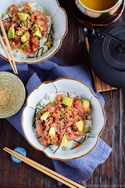A Japanese bowl containing avocado and negitoro (fatty tuna) on top of steamed rice.