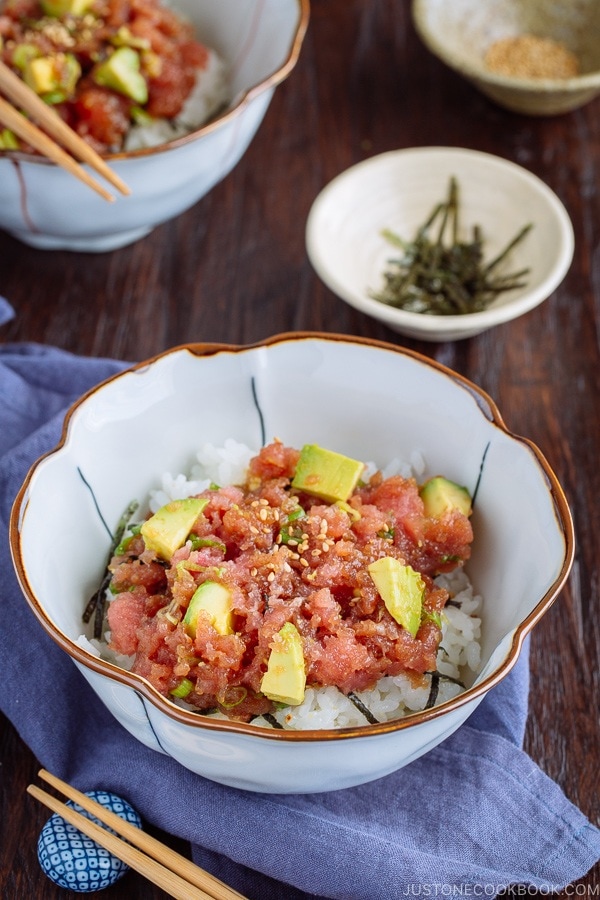 A Japanese bowl containing avocado and negitoro (fatty tuna) on top of steamed rice.