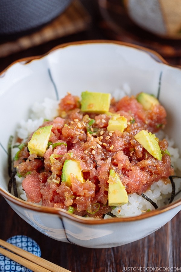 A Japanese bowl containing avocado and negitoro (fatty tuna) on top of steamed rice.