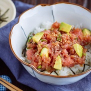 A Japanese bowl containing avocado and negitoro (fatty tuna) on top of steamed rice.
