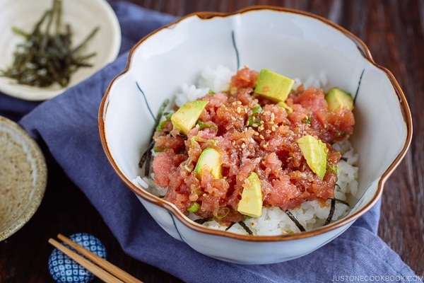 A Japanese bowl containing avocado and negitoro (fatty tuna) on top of steamed rice.