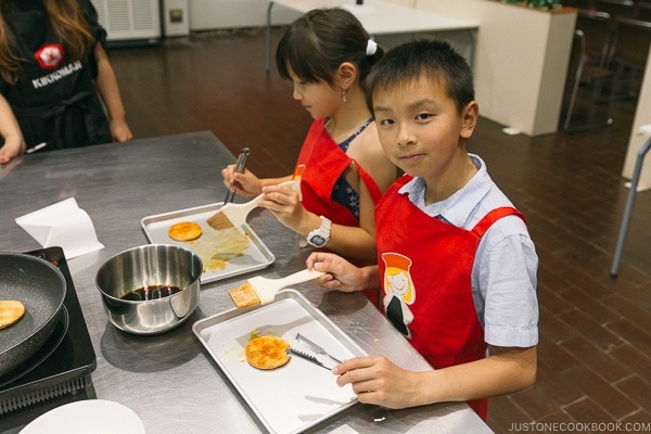 children brushing soy sauce on rice cracker at Kikkoman Factory in Noda Japan | justonecookbook.com