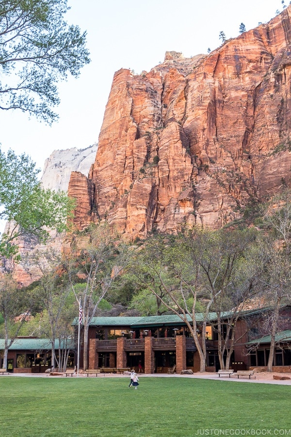 exterior of Zion Lodge with front lawn and rocky backdrop - Zion National Park Travel Guide | justonecookbook.com