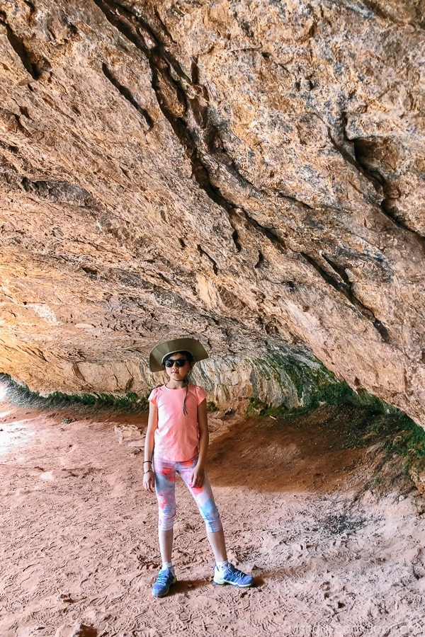 child inside an alcove on the Canyon Overlook Trail - Zion National Park Travel Guide | justonecookbook.com