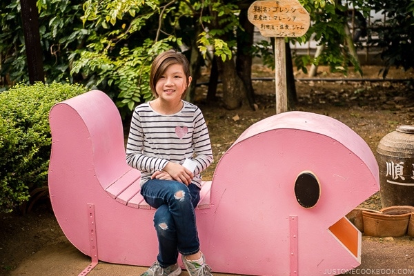 child sitting on wooden sculpture - Okinawa World | justonecookbook.com