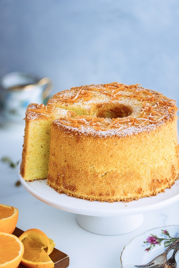 Orange Chiffon Cake on top of the cake stand. Chiffon cake has a hint of cardamom and powder sugar dusted on top.