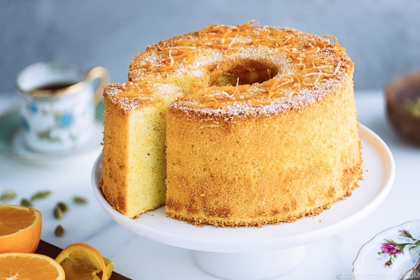 Orange Chiffon Cake on top of the cake stand. Chiffon cake has a hint of cardamom and powder sugar dusted on top.