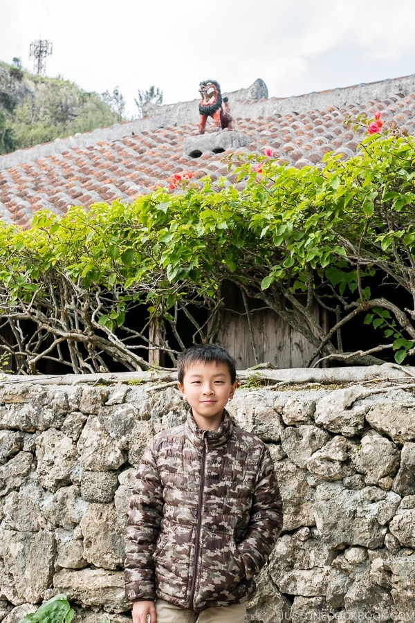 child in front of a traditional ryukyu house at Ryukyu Mura Okinawa | justonecookbook.com