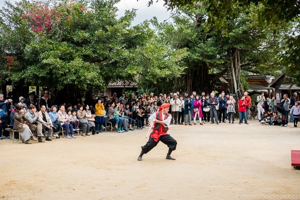 man performing traditional Ryukyu stick dance at Ryukyu Mura Okinawa | justonecookbook.com