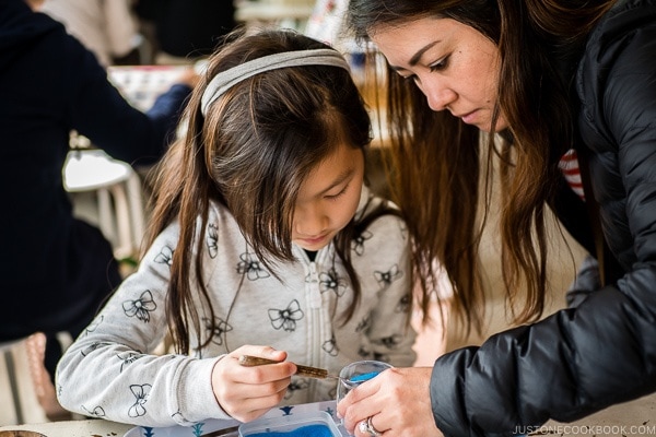 Nami helping child with art craft at Ryukyu Mura Okinawa | justonecookbook.com