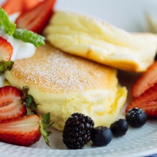 Japanese Souffle Pancakes with berries and fresh whipped cream.