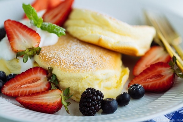 Japanese Souffle Pancakes with berries and fresh whipped cream.