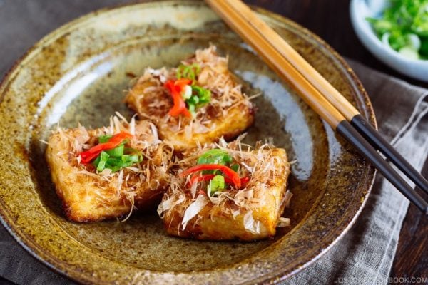 Three pieces of Teriyaki Tofu are placed on a Japanese blue plate | Easy. Japanese Recipes at JustOneCookbook.com