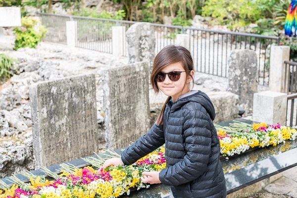 child dedicating flower at Himeyuri Peace Museum - Okinawa Travel Guide | justonecookbook.com