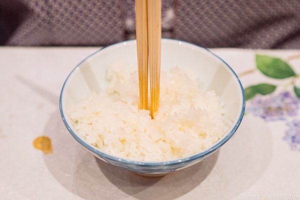 A bowl of rice with Chopsticks sticking up in the middle of it