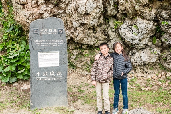 Just One Cookbook children standing next to world heritage sign at Nakagusuku Castle - Okinawa Travel Guide | justonecookbook.com