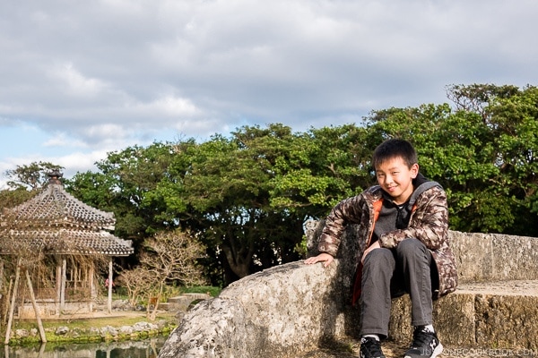 boy sitting on stone bridge at Shikinaen - Okinawa Travel Guide | justonecookbook.com
