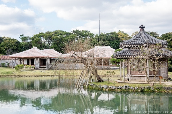 lake with pagoda on an island and buildings in the background at Shikinaen - Okinawa Travel Guide | justonecookbook.com