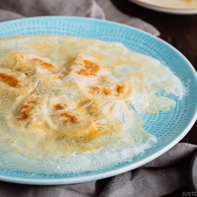 Gyoza with Wings called Hanetsuki Gyoza (#羽根つき餃子) is a Japanese dumpling with flavorful and juicy filling and fried to crispy perfection!