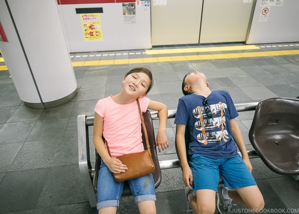 Just One Cookbook children exhausted sitting on bench in Shinjuku Station - Shinjuku Travel Guide | justonecookbook.com