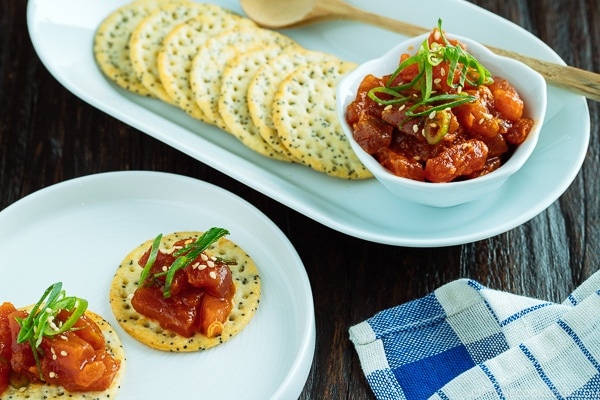 Spicy Tuna served with crackers garnished with scallion on top.