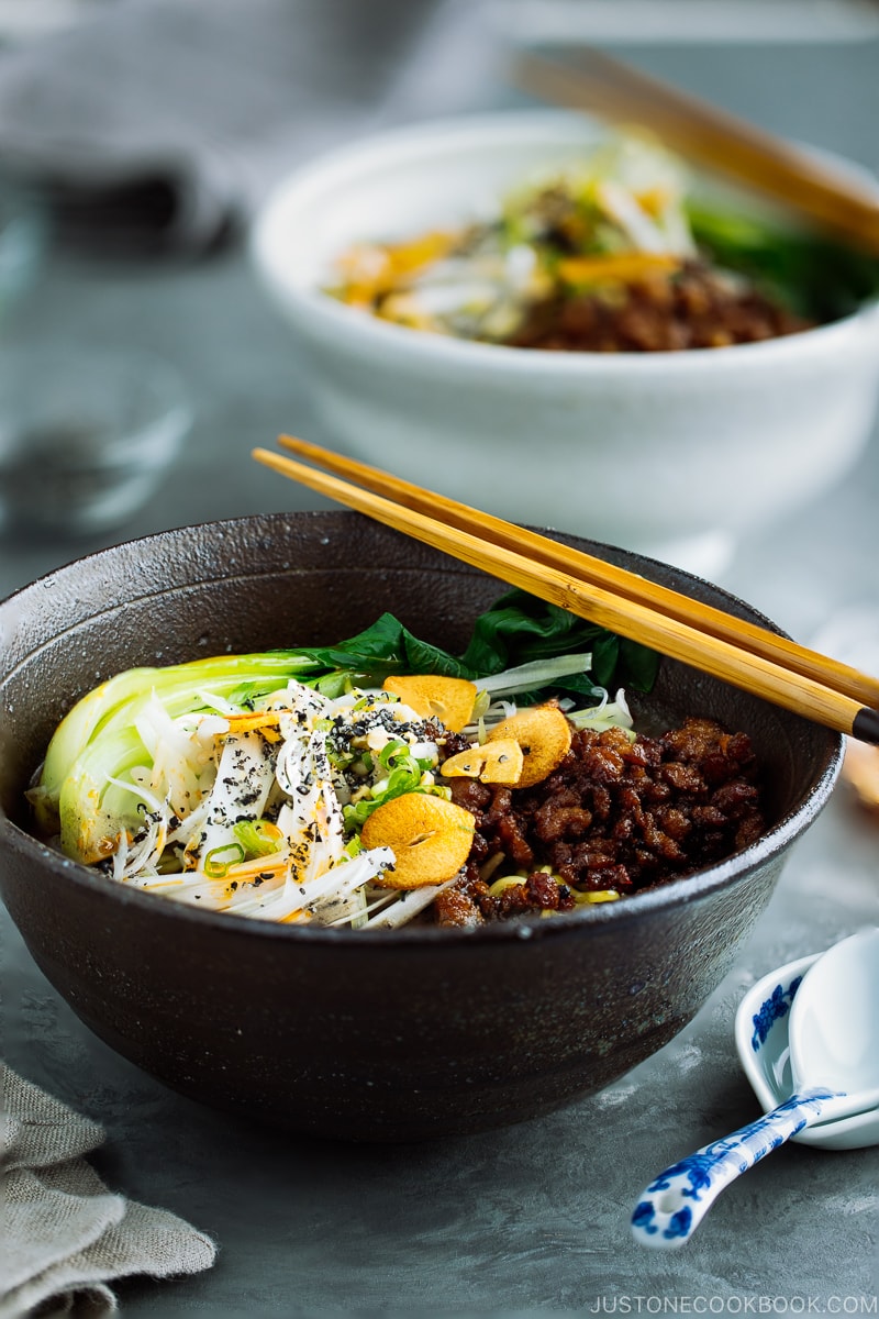 A black bowl containing Black Sesame Dan Dan Noodles.