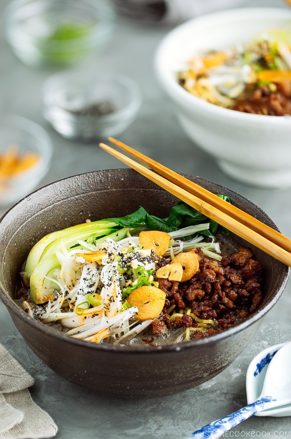 Black Sesame Dan Dan Noodles served with chili oil and garlic chips.