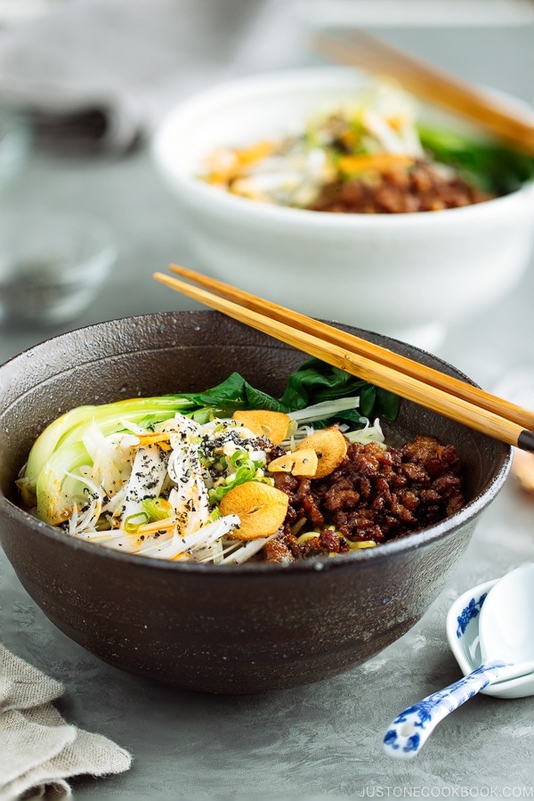 Black Sesame Dan Dan Noodles served with chili oil and garlic chips.