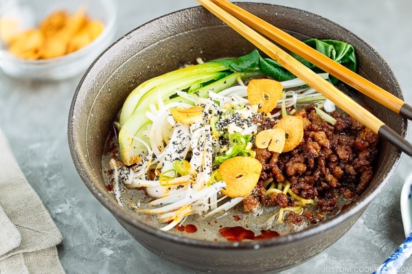 Black Sesame Dan Dan Noodles served with chili oil and garlic chips.