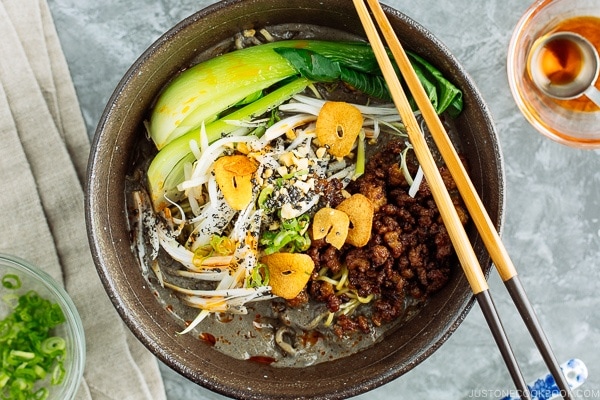Black Sesame Dan Dan Noodles served with chili oil and garlic chips.