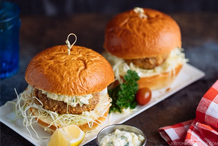 Menchi Katsu Sandwich is a ground meat patty coated with crispy panko and deep fried into golden brown. It is then topped with thinly sliced cabbage and homemade tartar sauce, and sandwiched in soft brioche buns.