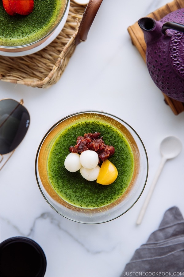 Matcha Vegan Panna Cotta served in a glass bowl, topped with mochi, red bean paste, and candied chestnut.