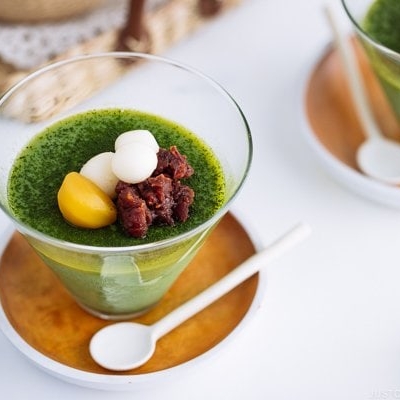 Matcha Vegan Panna Cotta served in a glass bowl, topped with mochi, red bean paste, and candied chestnut.